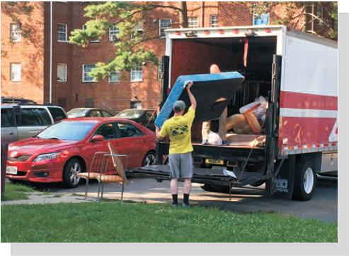 Volunteers load furniture onto delivery trucks for needy families
